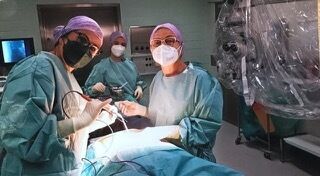 A team of doctors performing a neurosurgical procedure in the operating theatre